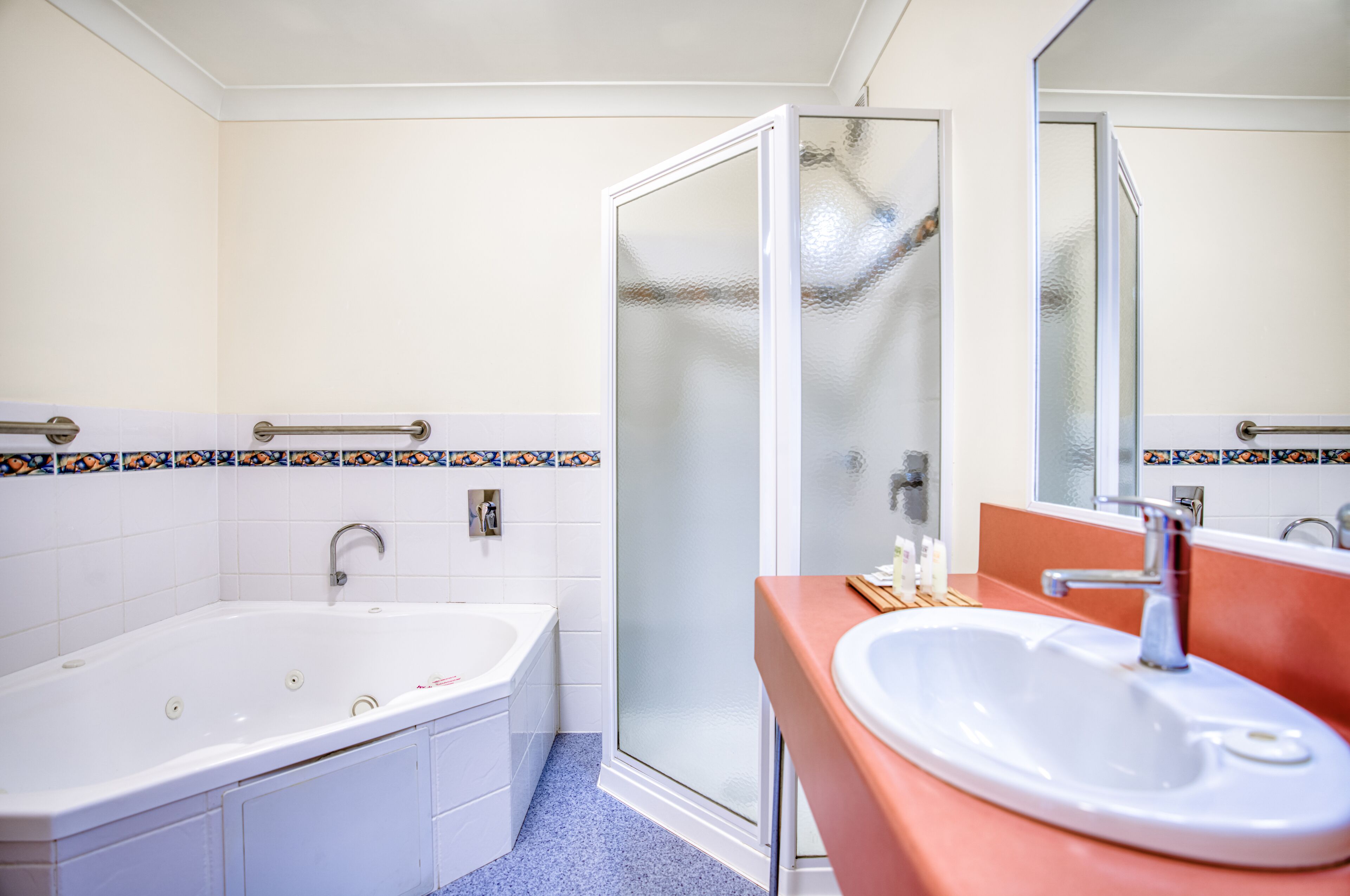 A bathroom with a bathtub, a sink, and a glass shower enclosure.