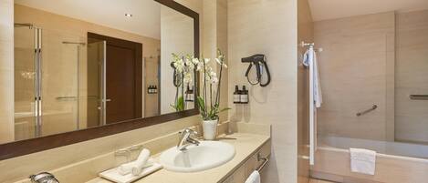 A modern bathroom with two sinks, a large mirror, a hairdryer, and a shower area.