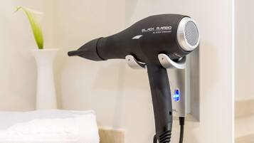 A hair dryer mounted on a wall in a bathroom.