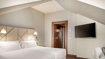 A modern hotel room with a large bed, a flat-screen TV mounted on the wall, and a wooden door.
