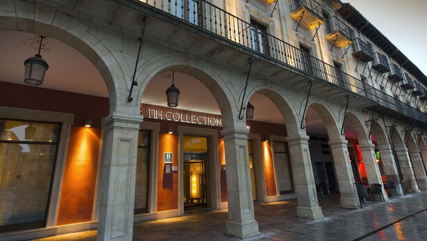 A building with a "1H COLLECTION" sign, arched entrances, and a balcony with railings. - NH Collection León Plaza Mayor (León)