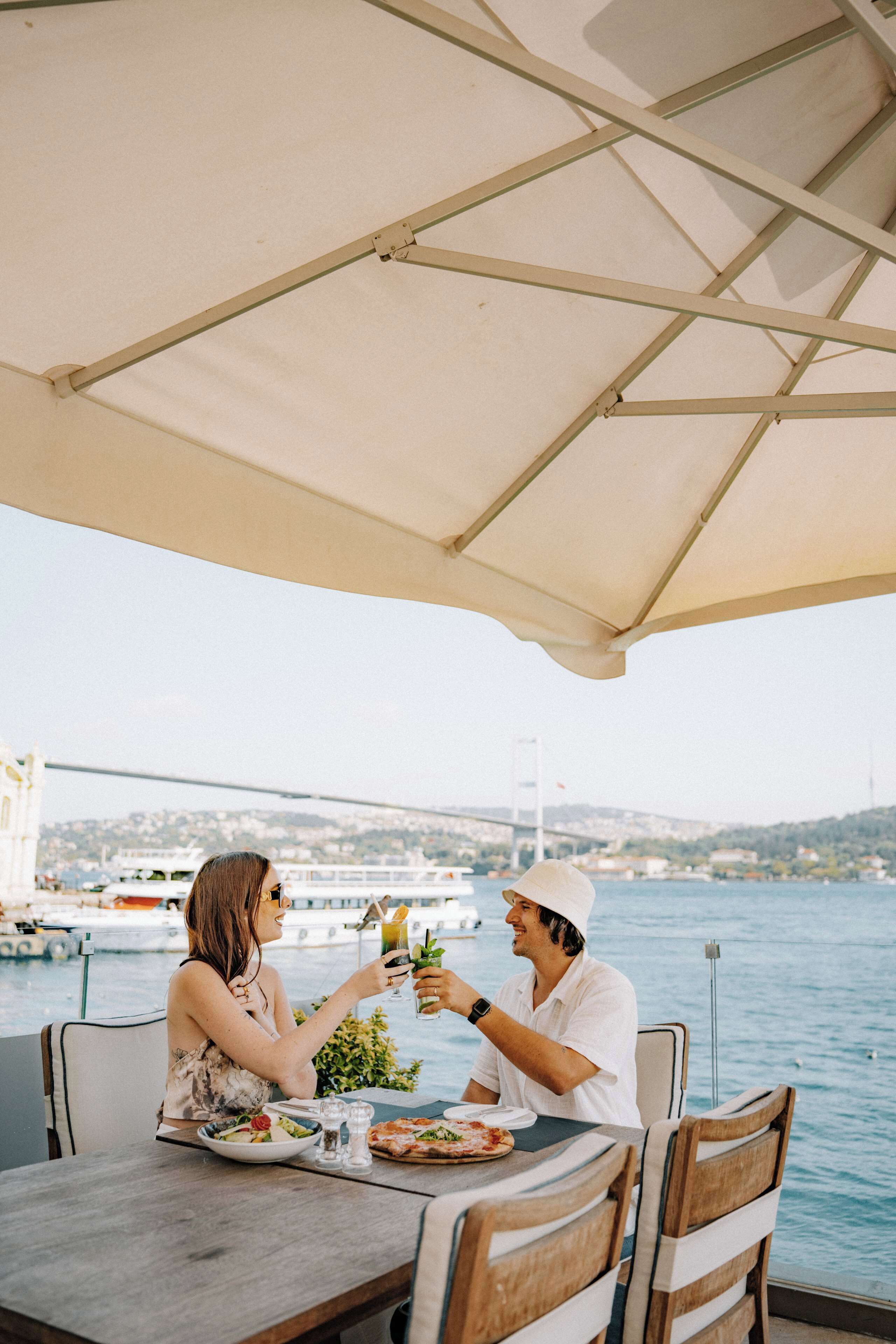 A dining table with a view of a bridge and water.