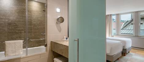 Un baño moderno con cabina de ducha de vidrio, bañera y tocador con espejo.