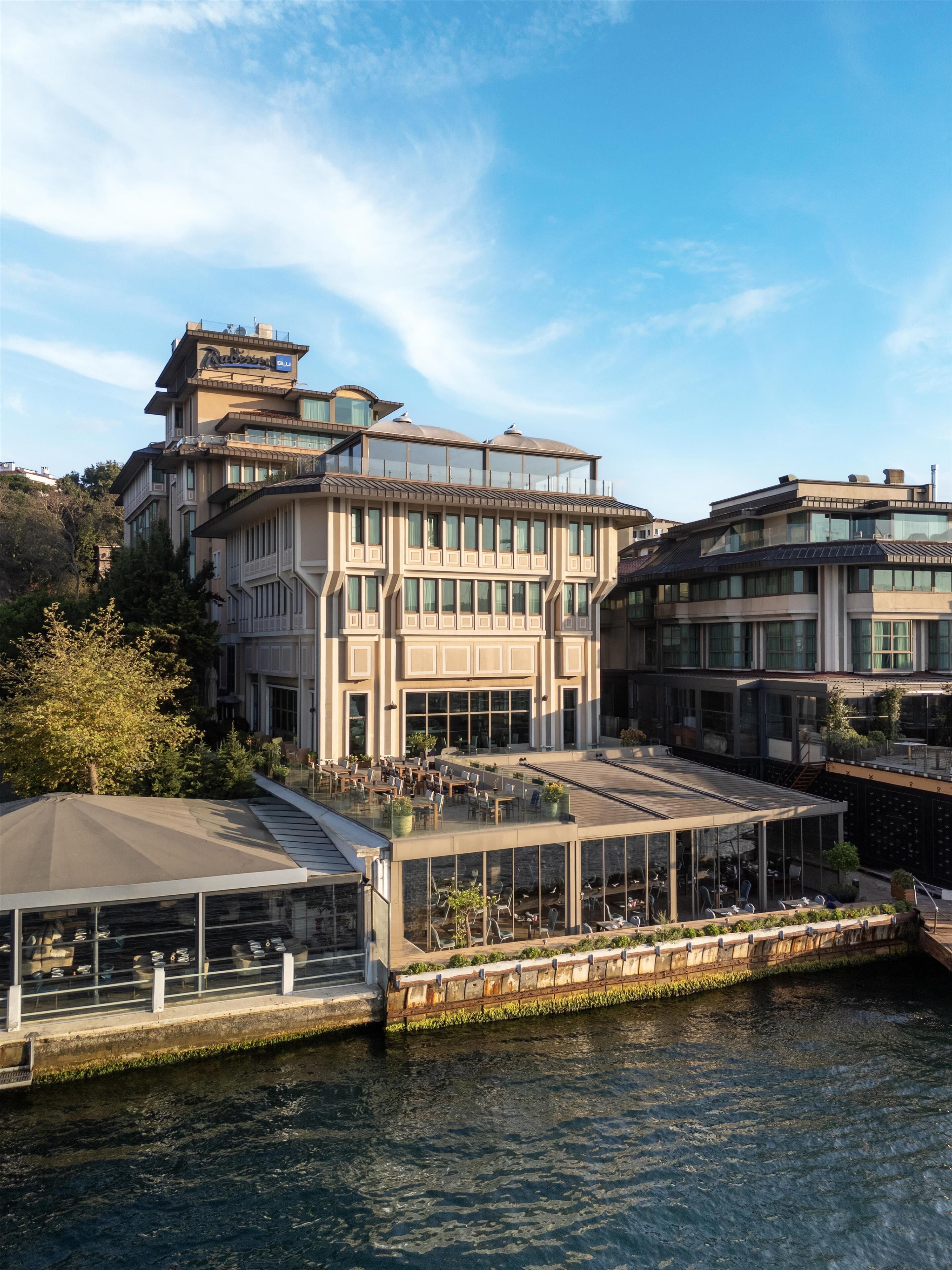 Un hotel moderno con terraza en la azotea y vistas al agua.