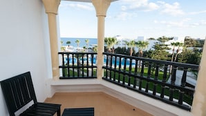 A balcony with a view of a pool and palm trees, featuring two columns and a black railing. - L´Orient Palace Resort & Spa (Sousse)