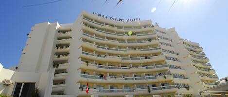 A multi-story hotel with balconies, a flag, and a sign for the Union Internationale de Boxe.