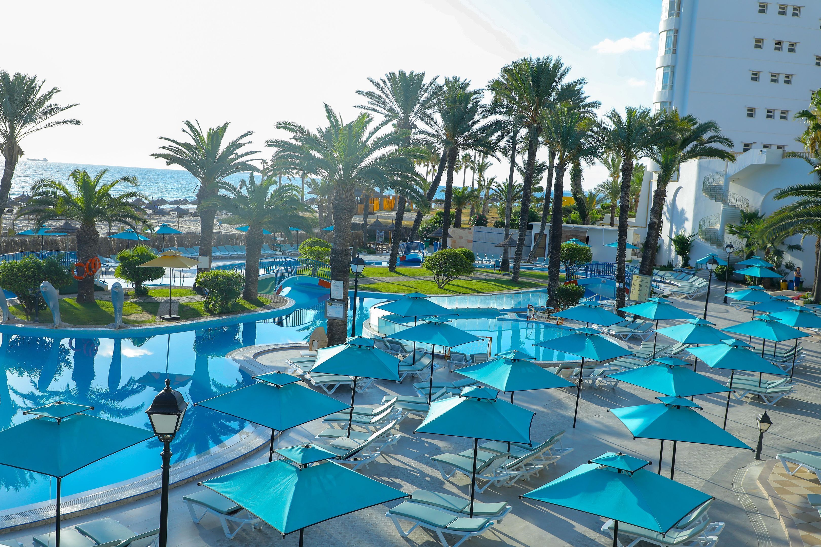 Piscine couverte, piscine extérieure, parasols de plage, chaises longues