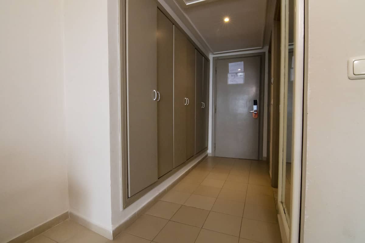 A hallway with a sliding door, a door with a lock, and a light fixture on the ceiling.