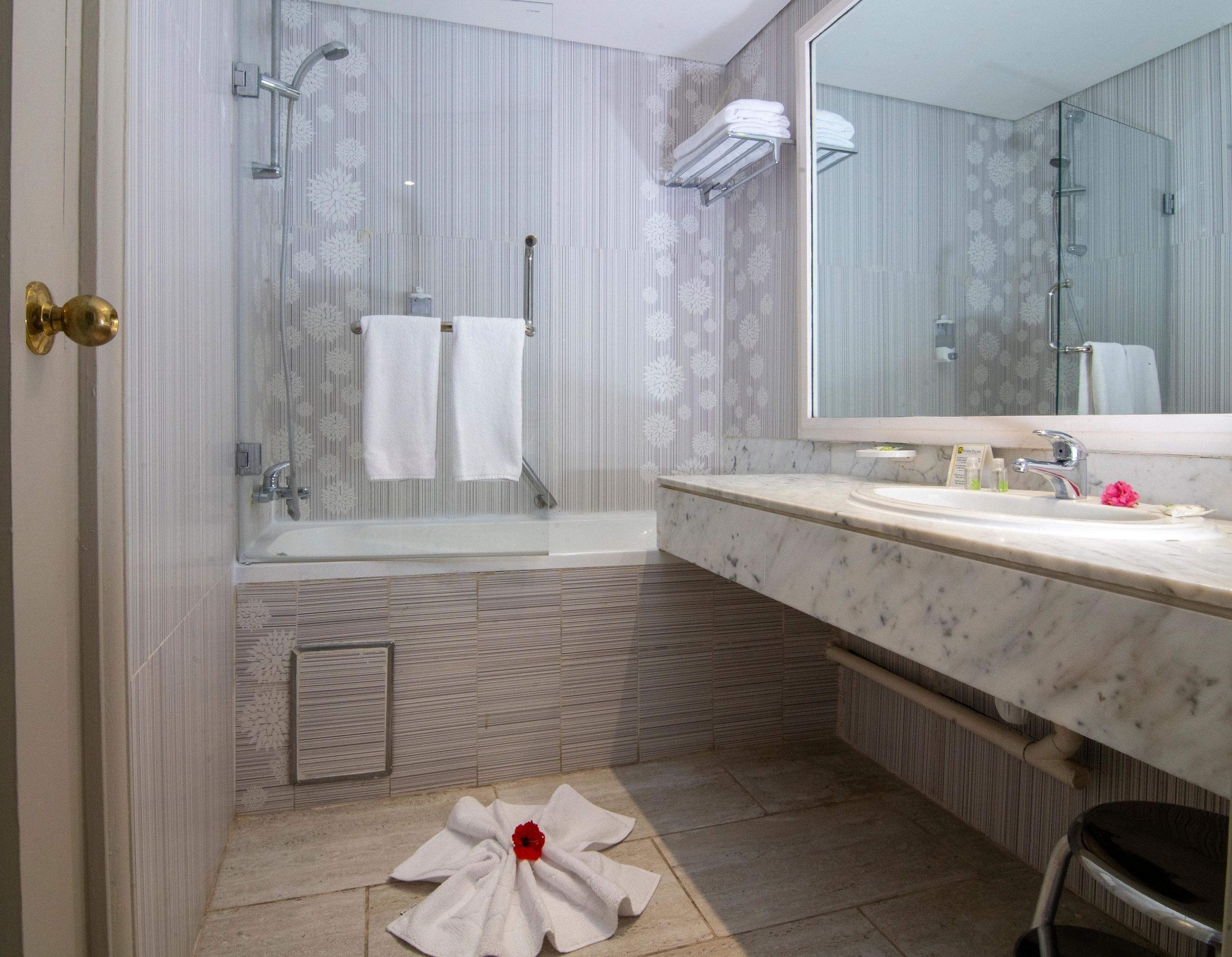 A modern bathroom with a shower, a sink, and a toilet.