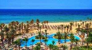 Privat strand, hvit sand, solsenger og parasoller
