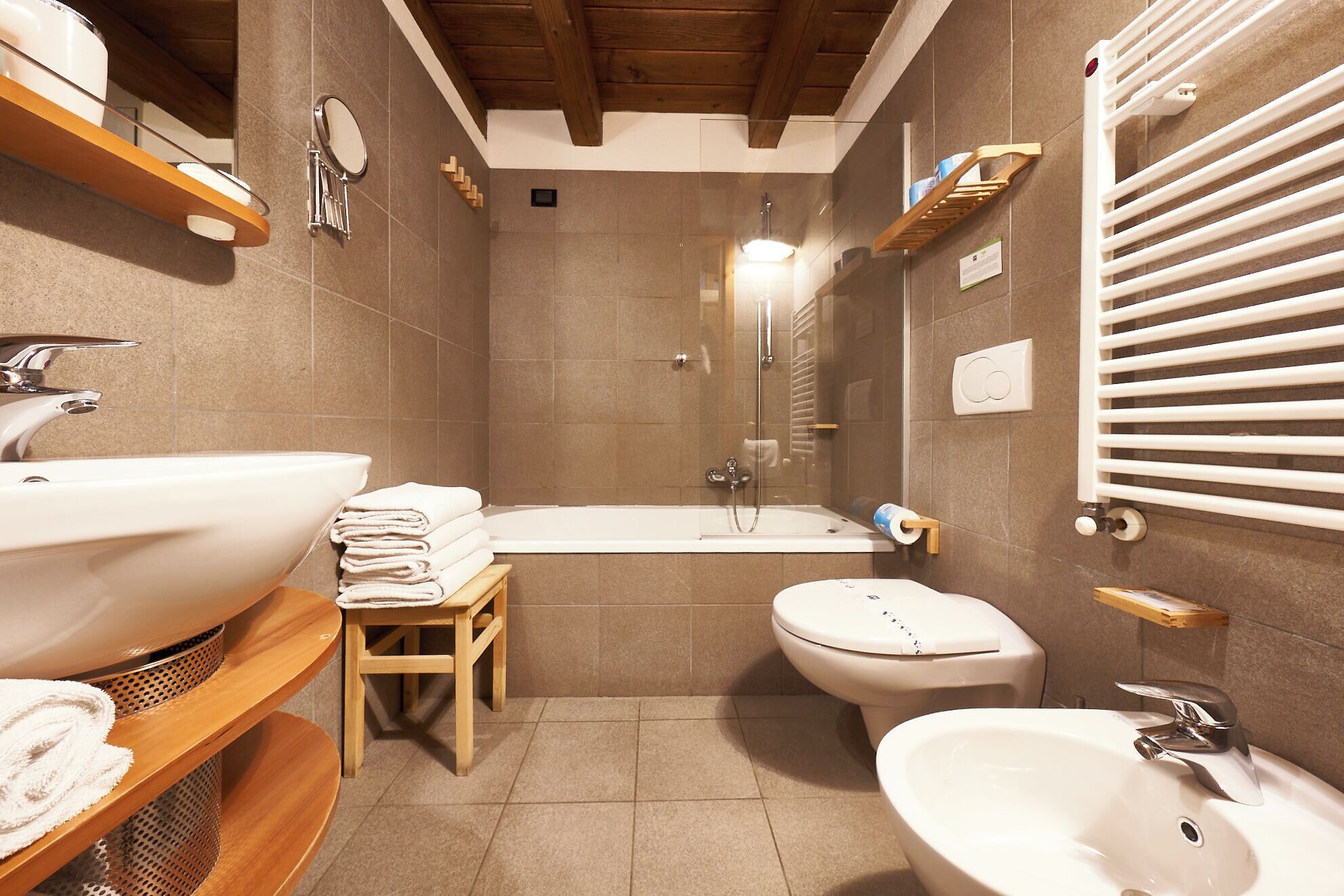 A bathroom with a sink, toilet, bidet, and bathtub.