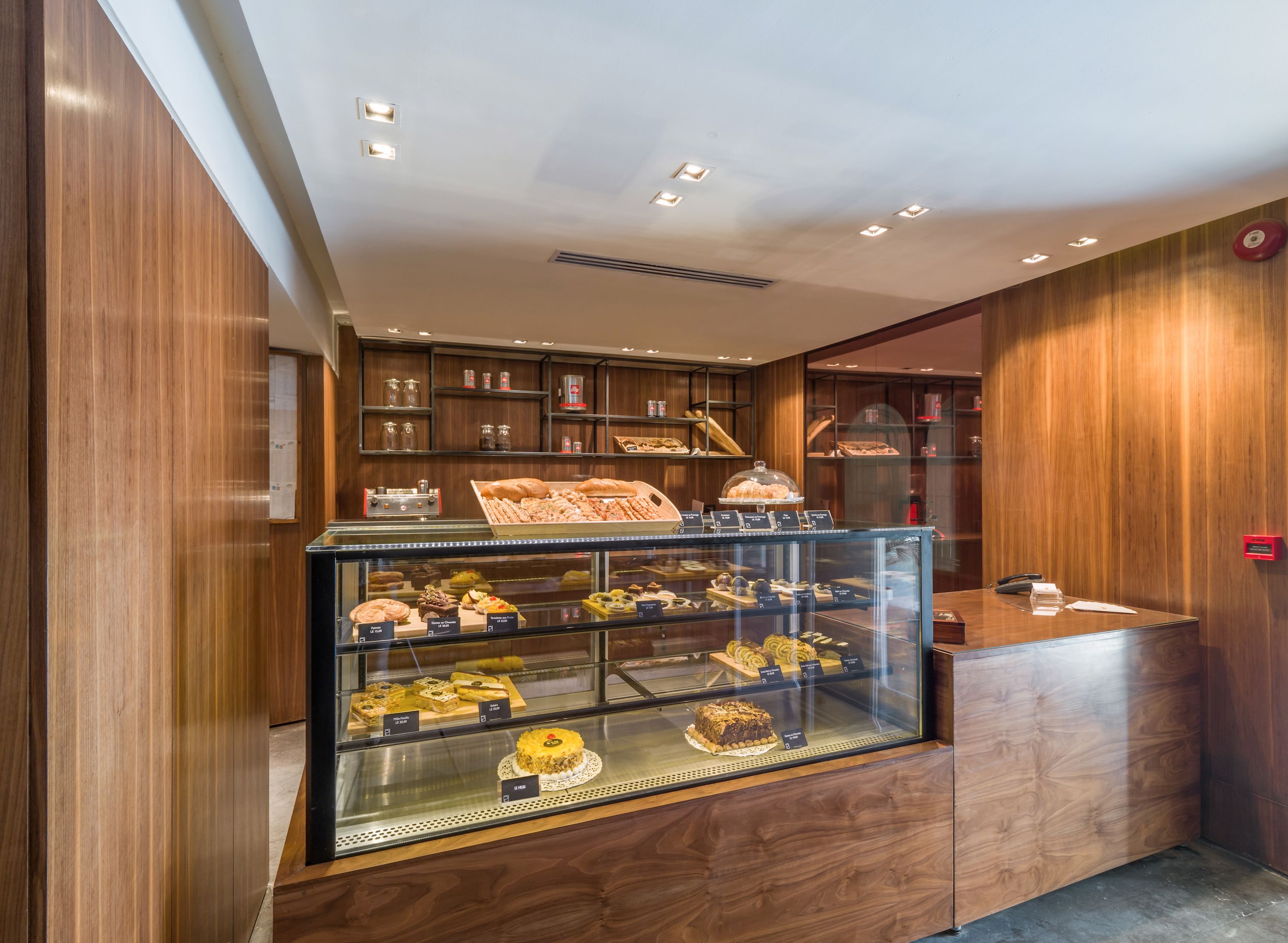 A bakery display case with various baked goods and a wooden reception desk.