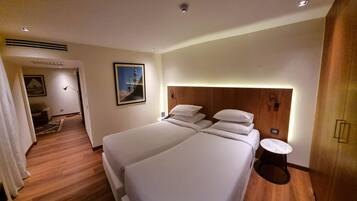 A hotel room with a large bed, a bedside table, a lamp, and a picture on the wall.