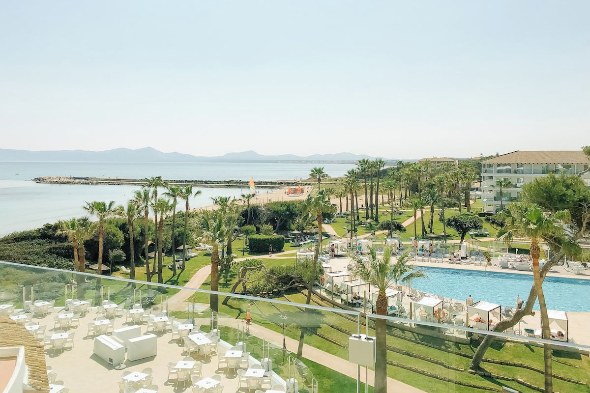 A resort with a pool, beach, and mountain views.