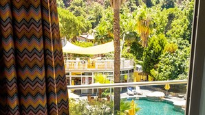 Un balcón con vistas a una piscina, sillas y una mesa.