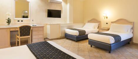 Habitación de hotel con dos camas, un escritorio, una silla, un televisor y un espejo.