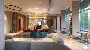 Een modern interieur met een bar, zitplaatsen en een groot raam voor natuurlijk licht.