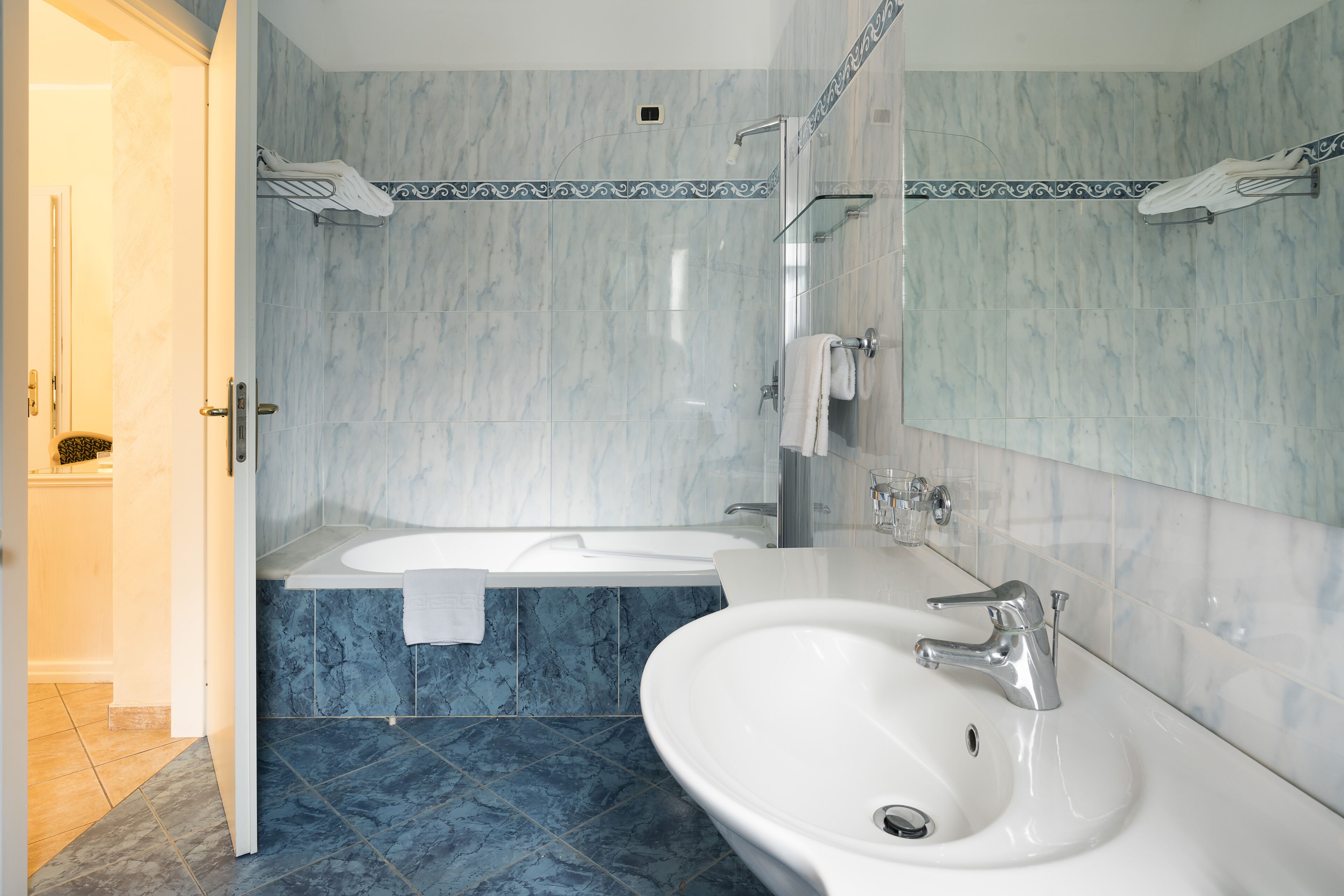 A modern bathroom with a bathtub, a large sink, and a shower area.