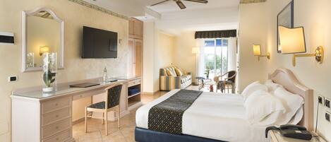 A hotel room with a bed, desk, chair, and a television on the wall.