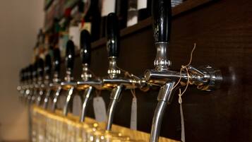 A row of beer taps with labels, mounted on a wooden bar counter.