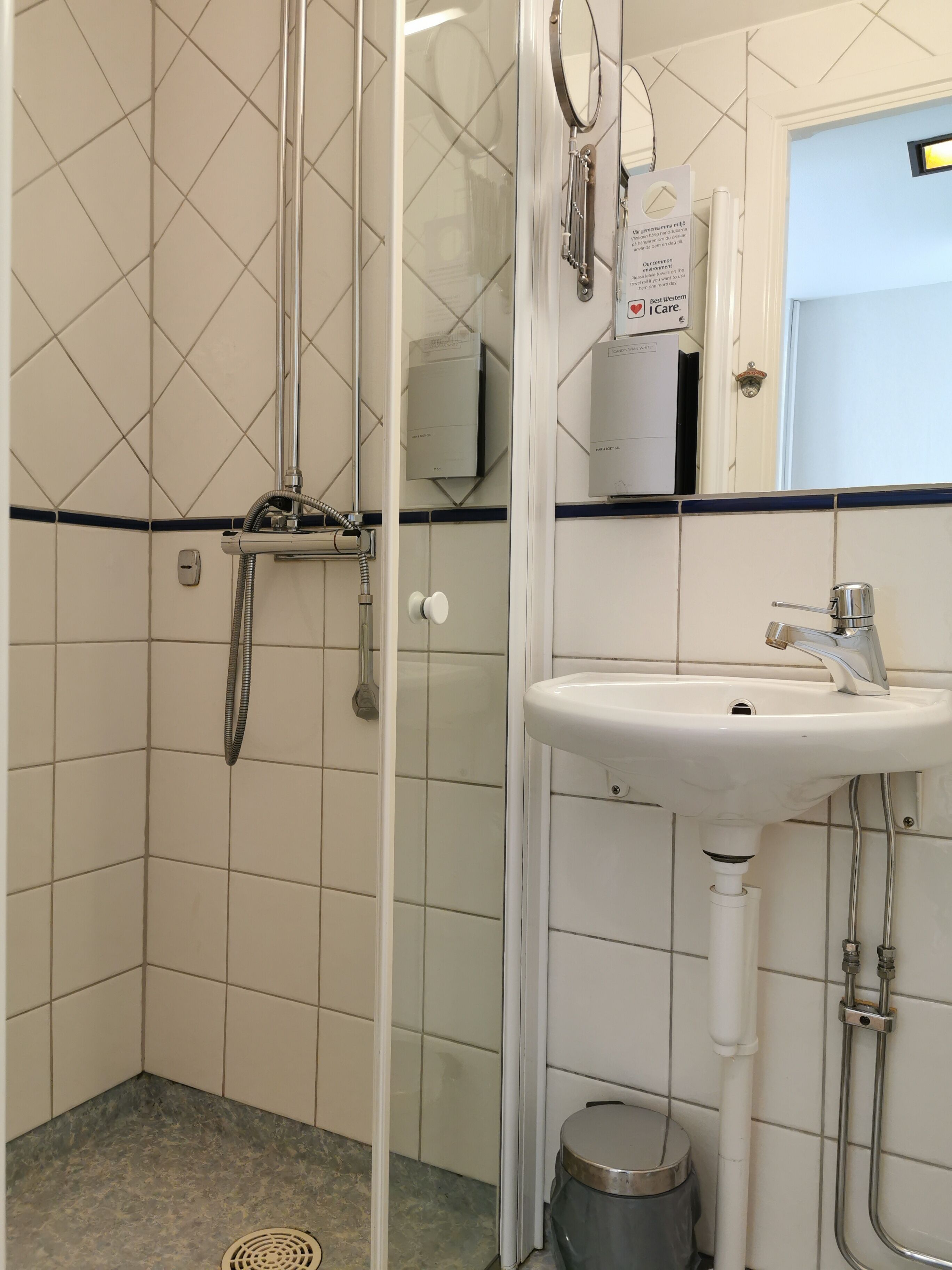 A bathroom with a glass-enclosed shower, a sink, and a toilet.