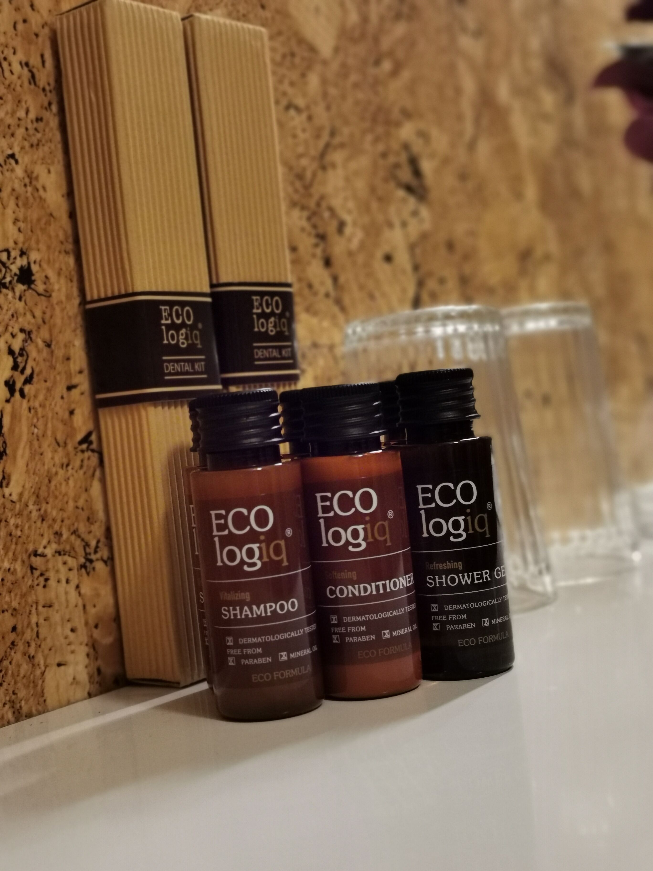 Un estante con kit dental ECO logic, champú, acondicionador y gel de ducha.