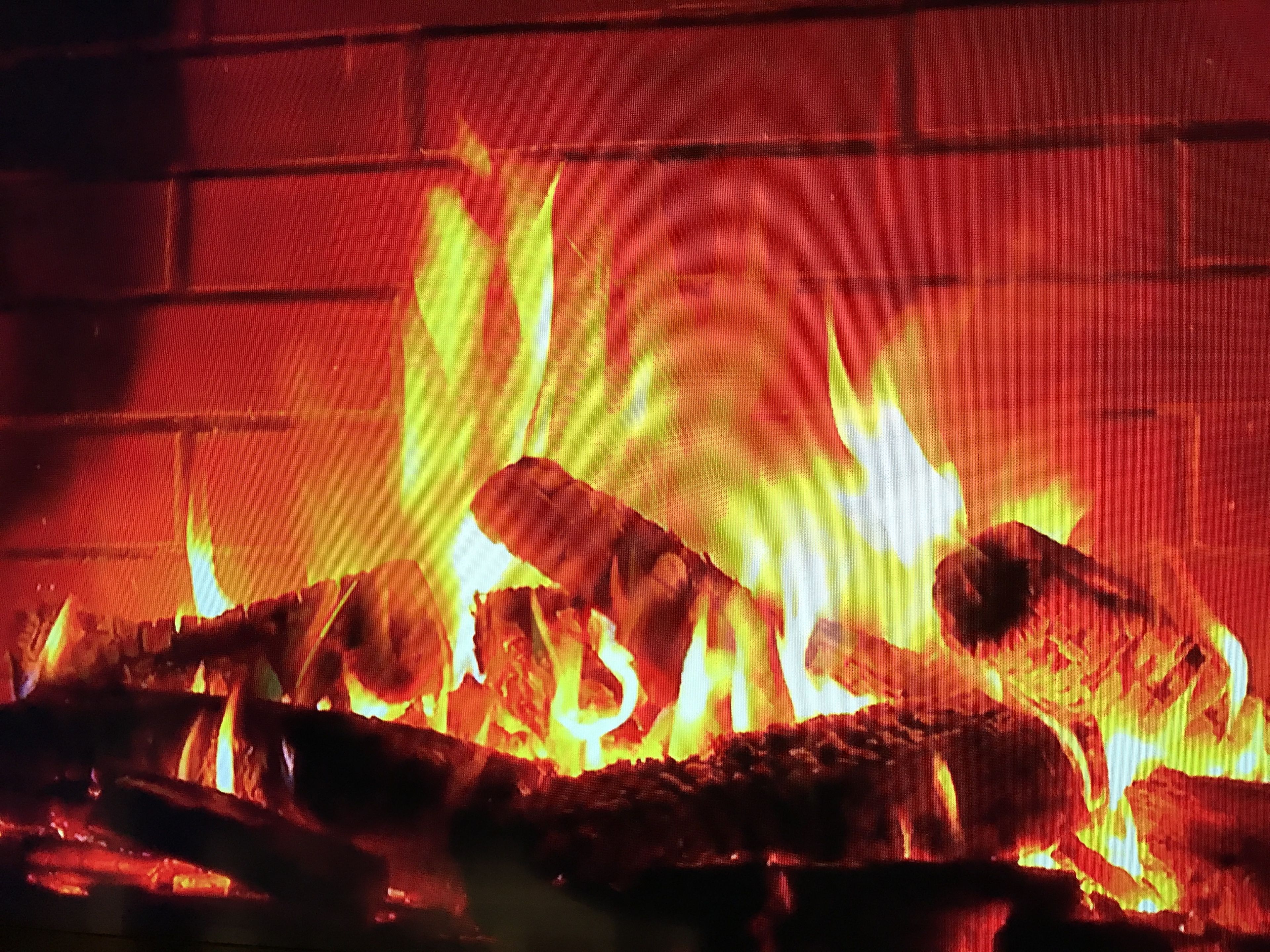 Primer plano de leña ardiendo en una chimenea.