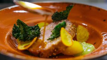 A plate of food with a piece of meat, broccoli, and lemon slices.