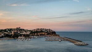 Une ville côtière dotée d’un port de plaisance, de bâtiments construits sur une falaise et d’un ciel dégagé.