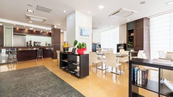 En modern hotellobby med en bar, en sittgrupp och en receptionsdisk.