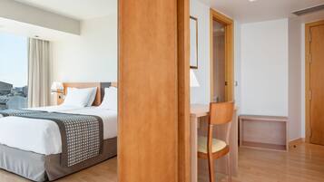 A hotel room with a bed, a desk, and a chair.