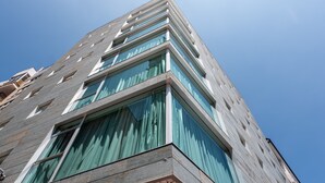 A modern high-rise building with large windows and a corner entrance.