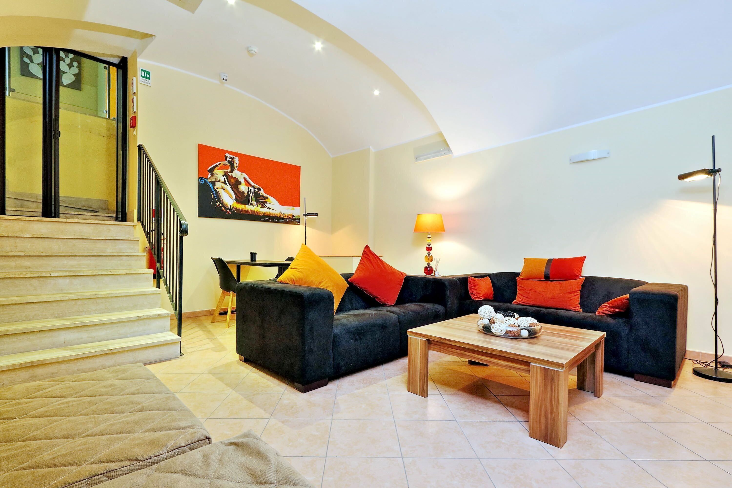 A living room with a sofa, coffee table, and a staircase.