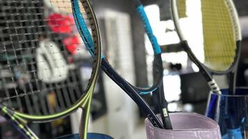 A collection of tennis rackets leaning against a wall.