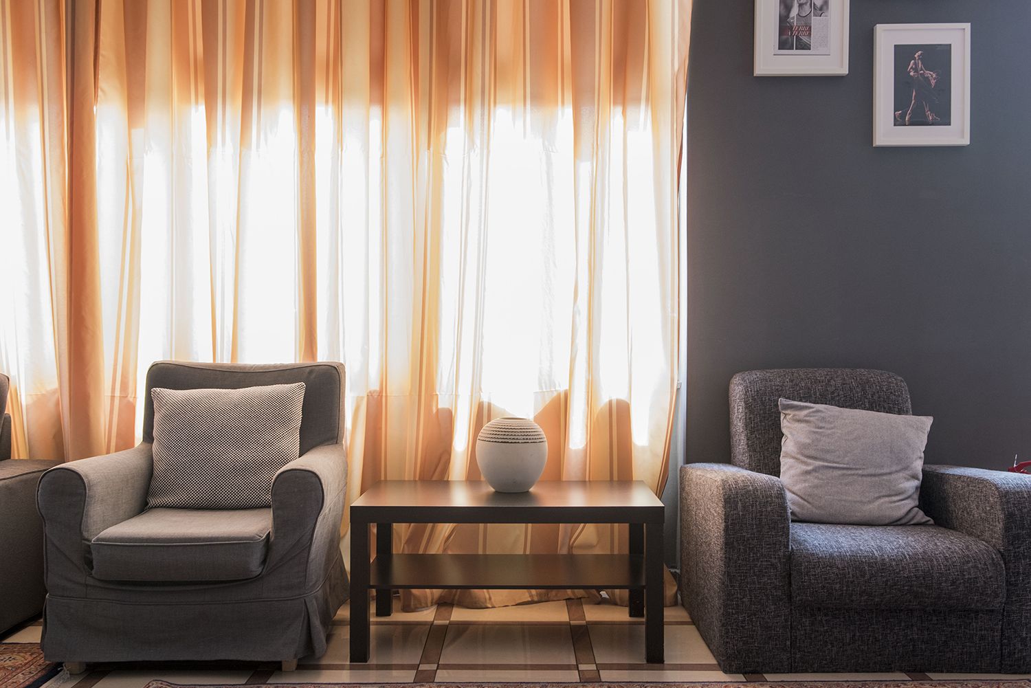Una sala de estar con dos sillones, una mesa de centro y un florero.