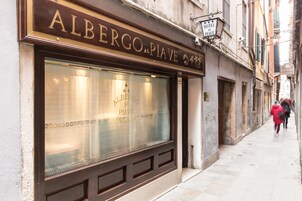 The exterior of Albergo al Piave hotel with a large window and a sign above the entrance.
