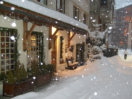 A snow-covered building with a wooden facade and a snow-covered entrance.