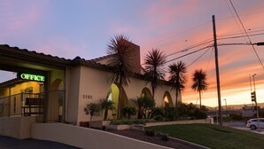 A building with a sign reading "OFFICE" and the number "2102" on the facade. - El Castell Motel (Monterey)