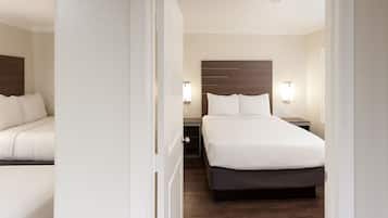 Hotellihuone, jossa on sänky, yöpöydät ja yöpöytälamppu.