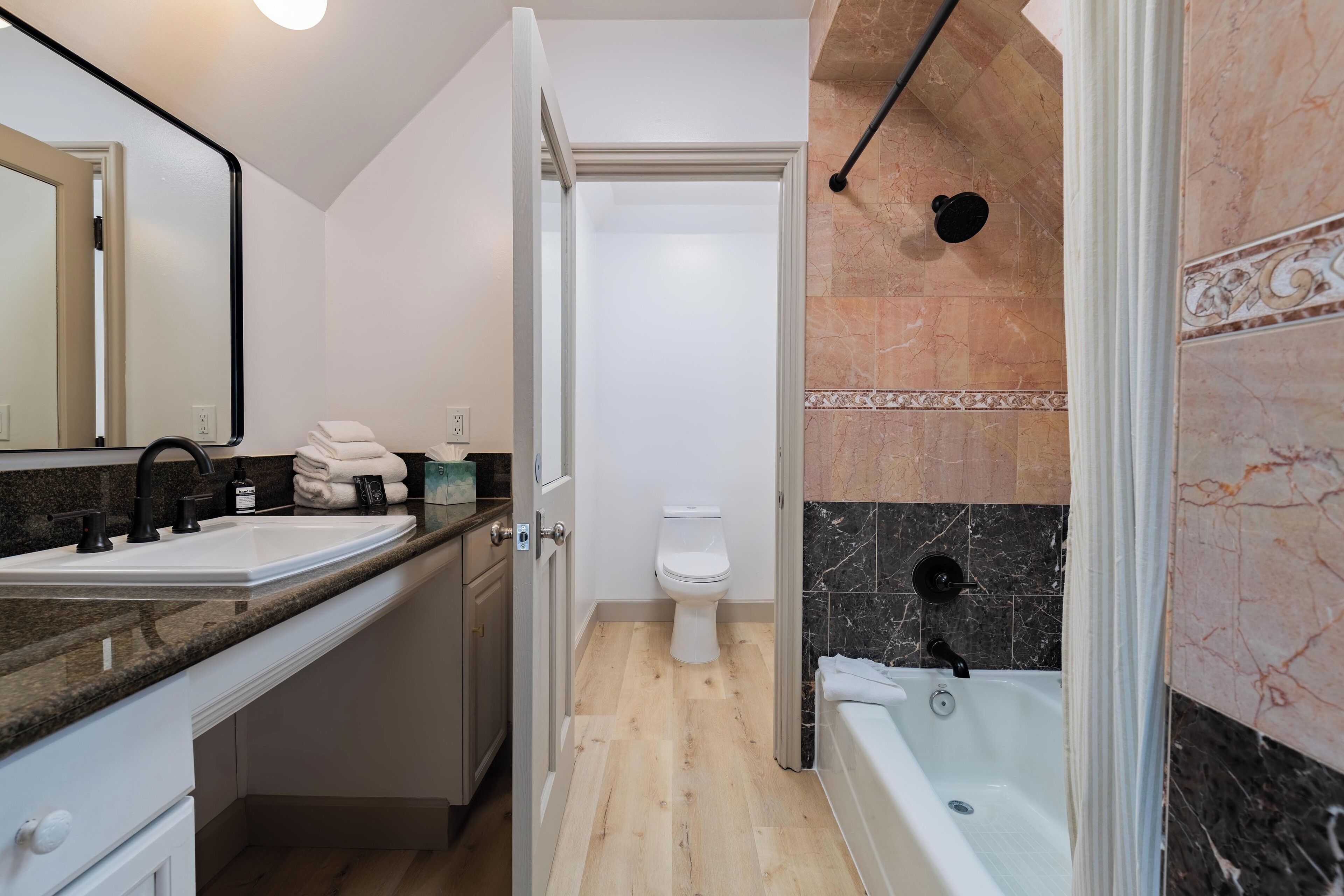 Une salle de bain moderne avec un lavabo, des toilettes et une baignoire.