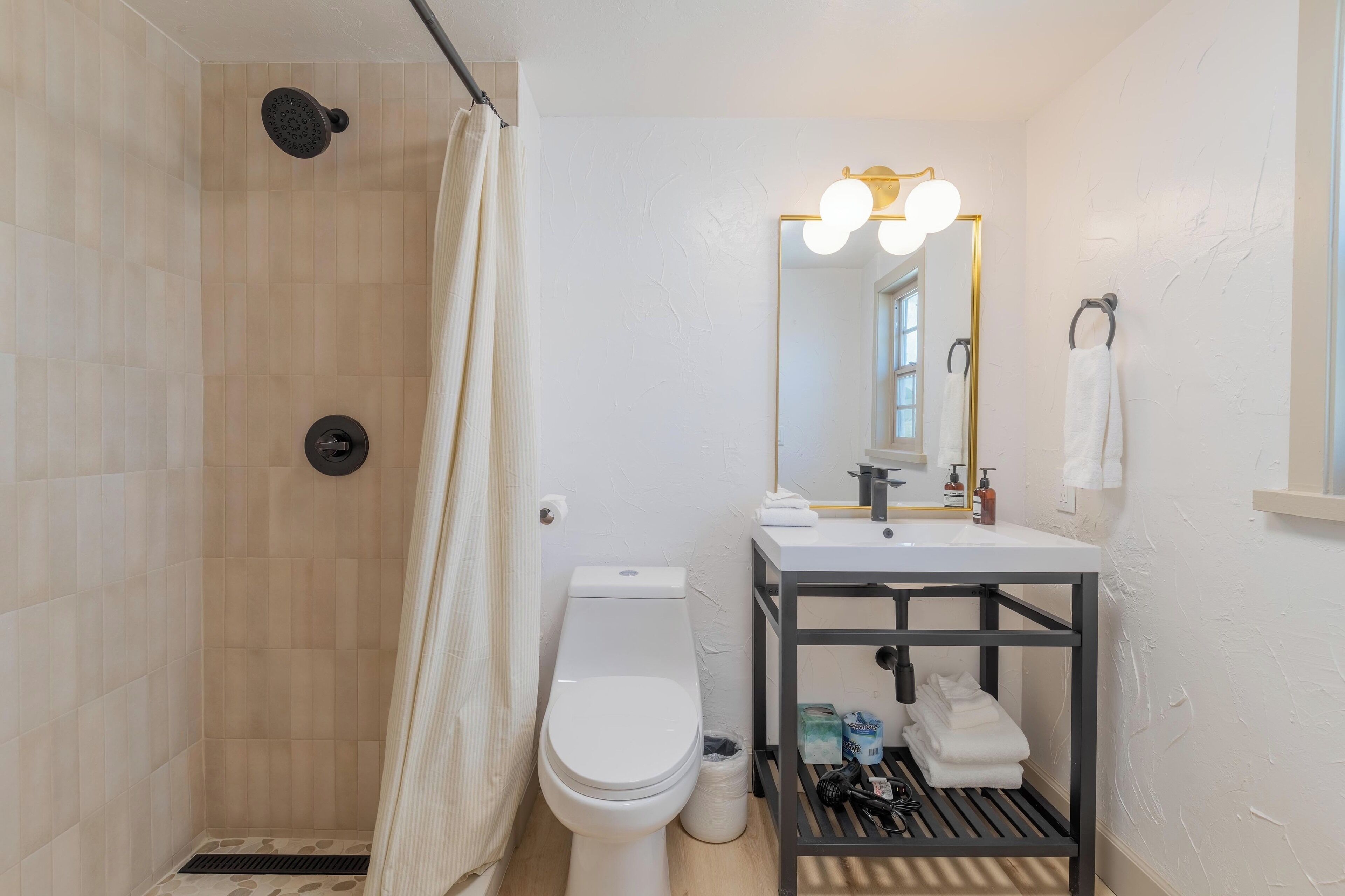 solstice king suite | bathroom | hair dryer, slippers, towels, soap