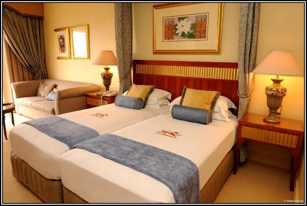 Een hotelkamer met twee bedden, een bank en een bureau.