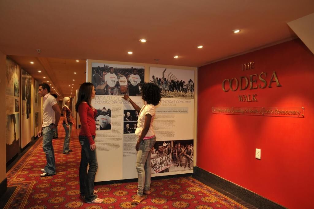 A hallway with a red wall and a poster titled "The Codesa Walk".