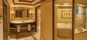 Um banheiro luxuoso com um espelho grande, pias duplas, banheira e chuveiro envidraçado.