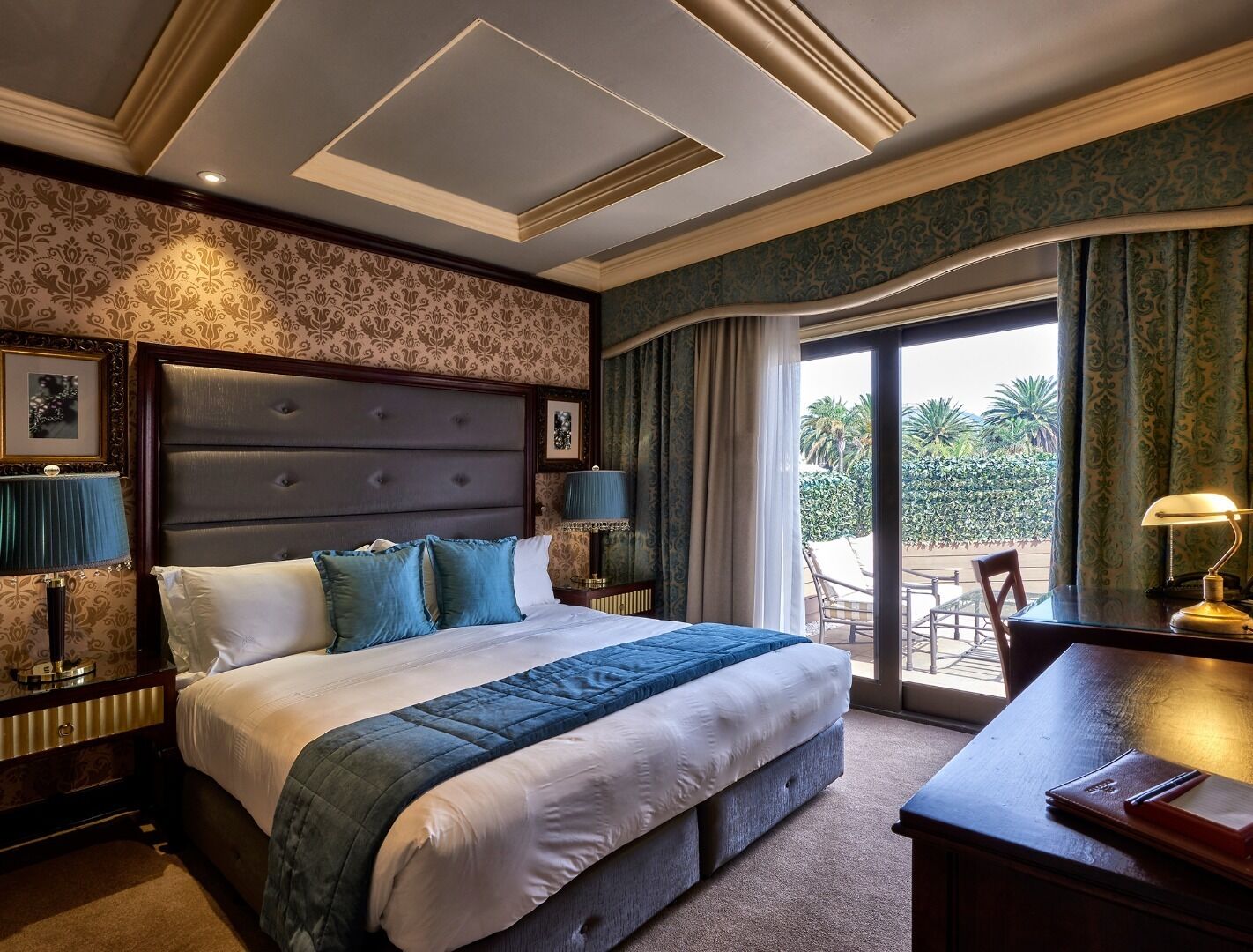 Habitación de hotel con una cama grande, un escritorio y vistas al exterior.
