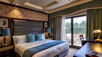 Habitación de hotel con una cama grande, un escritorio y vistas al exterior.