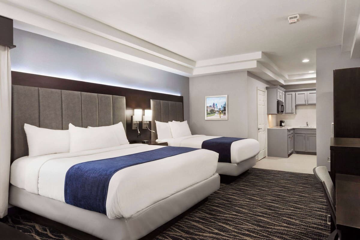 Une chambre d’hôtel avec deux lits, une kitchenette et une vue sur la ville.