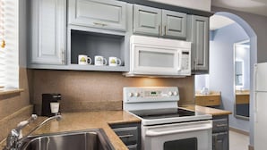 A kitchen with granite countertops, stainless steel appliances, and light blue cabinetry.