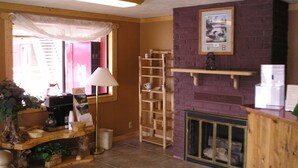 Un salon chaleureux avec une cheminée, une étagère en bois et une échelle.
