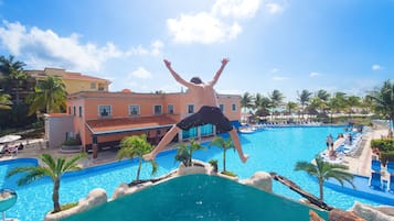 Guests can enjoy a refreshing swim in the resort's pool surrounded by lush palm trees.